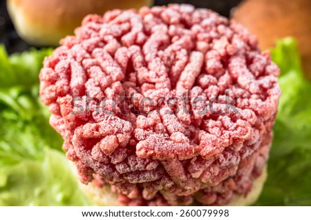 Frozen hamburger ground beef on lettuce