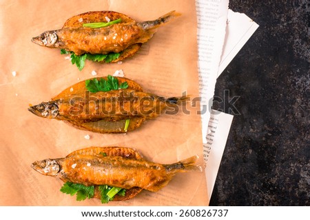Fish and chips, fish in batter into slices of French fries on paper and newspaper