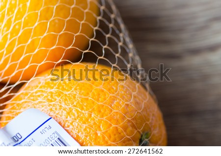 Two oranges in the store with a price tag on the shelf close-up