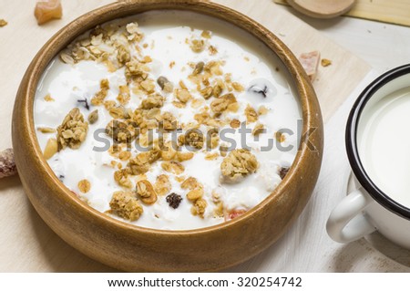 Muesli with fruit and nuts and milk in a wooden bowl rustic style