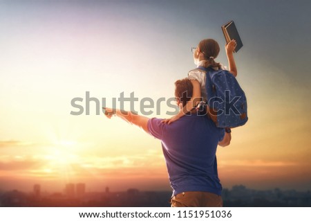 Parent and pupil of primary school on sunset background. Man and girl with backpack behind the back. Beginning of lessons. First day of fall.