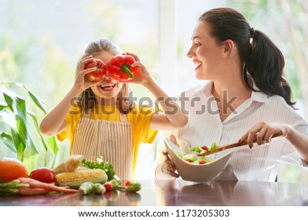 Healthy food at home. Happy family in the kitchen. Mother and child daughter are preparing the vegetables.