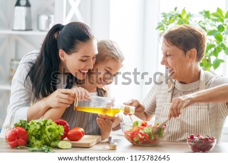 Healthy food at home. Happy family in the kitchen. Grandma, mother and child daughter are preparing the vegetables and fruit.