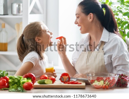 Healthy food at home. Happy family in the kitchen. Mother and child daughter are preparing the vegetables.
