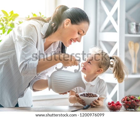 Healthy food at home. Happy family in the kitchen. Mother and child daughter are preparing breakfast.