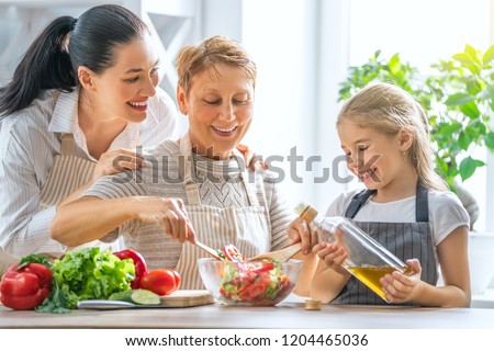 Healthy food at home. Happy family in the kitchen. Grandma, mother and child daughter are preparing the vegetables and fruit.