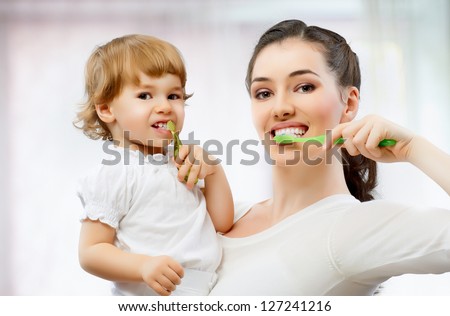 mother and daughter brush their teeth