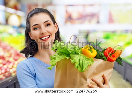 a woman holding a bag of fruit