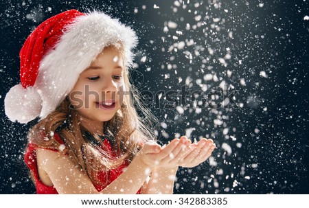 a Christmas miracle! happy little girl catching snowflakes in her hands