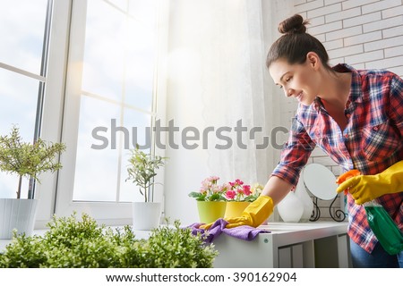 Beautiful young woman makes cleaning the house. Girl rubs dust.