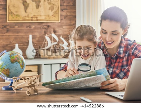 Go on an adventure! Happy family preparing for the journey. Mom, dad and daughter study the map and choose a route of travel.