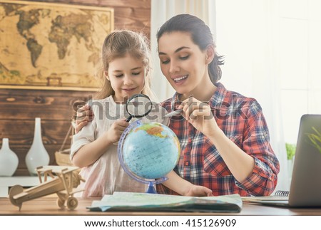 Go on an adventure! Happy family preparing for the journey. Mom and daughter study the map and choose a route of travel.
