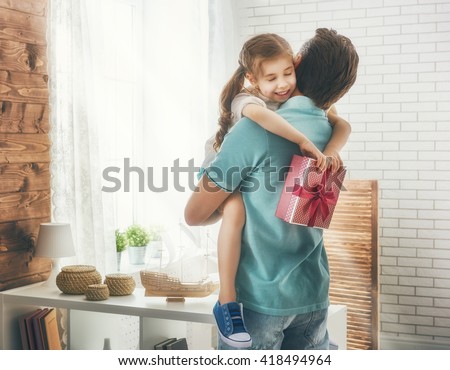 Happy loving family and Father\'s Day. Father and his daughter. Cute child girl gives a gift to dad.