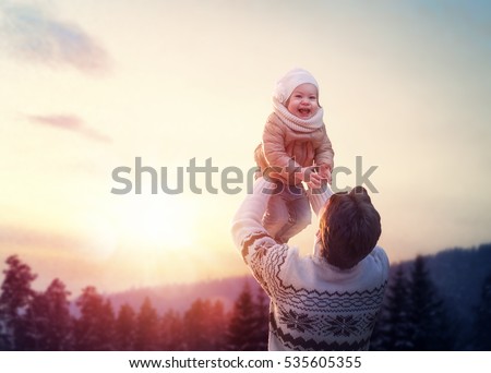 Happy loving family! Father and his daughter are playing and hugging outdoors. Cute little girl and daddy on snowy winter walk in nature. Concept of frost winter season.