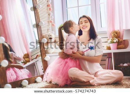 Happy loving family. Mother and her daughter in kids room. Funny mom and lovely child having fun indoors. Cute little girl is playing Princess fairy.