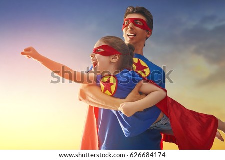 Happy loving family. Dad and his daughter playing outdoors. Daddy and child girl in an Superhero\'s costumes. Concept of Father\'s day.