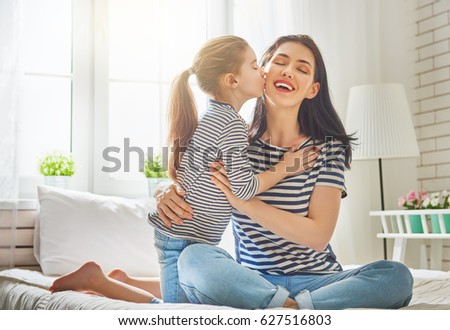 Happy mother\'s day! Mom and her daughter child girl are playing, smiling and hugging. Family holiday and togetherness.