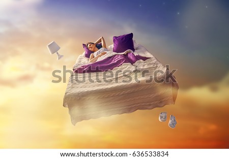 Woman\'s dreams. Pretty girl is flying in her bed trough star sky.