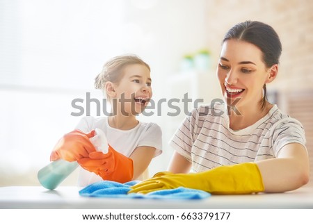 Happy family cleans the room. Mother and daughter do the cleaning in the house. A young woman and child girl are dusting. Cute little helper.