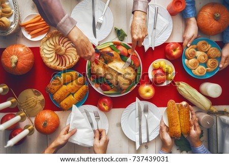 Happy Thanksgiving Day! Autumn feast. Family sitting at the table and celebrating holiday. Traditional dinner. Grandparents, parents and children.