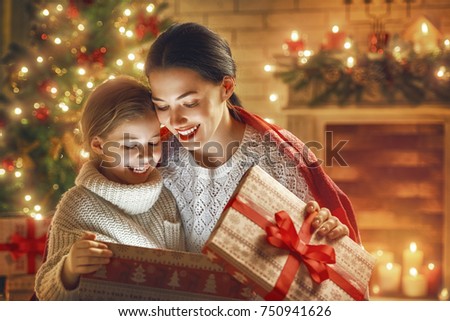 Merry Christmas and Happy Holiday! Loving family mother and child with magic gift box.
