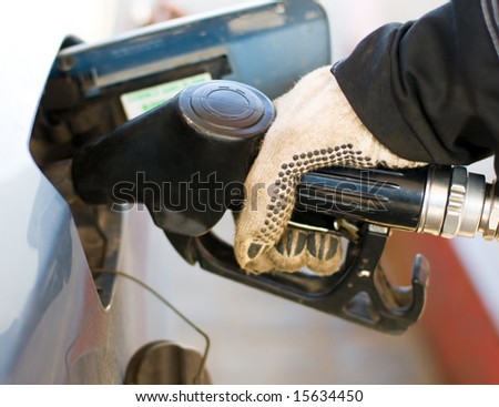 the hand filling the car with petrol