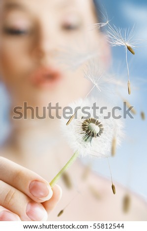 beautiful smiling girl with dandelion in hand