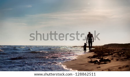 father and son to the sea at sunset