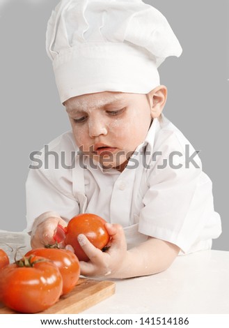 little boy chef cooking tomatoes