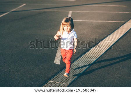 Little girl running away on the road