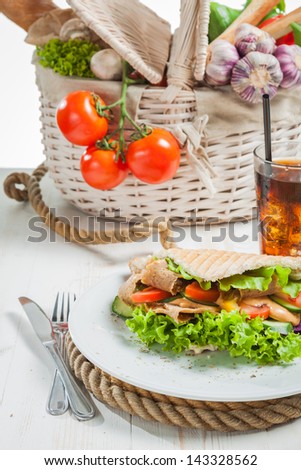 Kebab in pita bread next to vegetable basket
