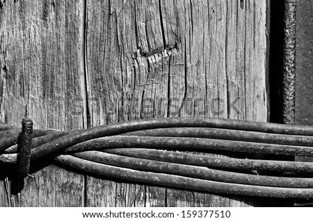Abstract urban background - wooden column and iron rail pulled together a steel wire.