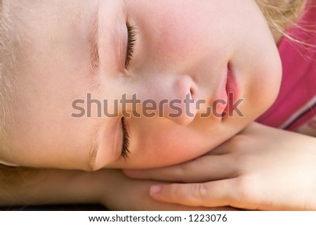 close-up of a beautiful young girl sleeping and dreaming outside in the garden