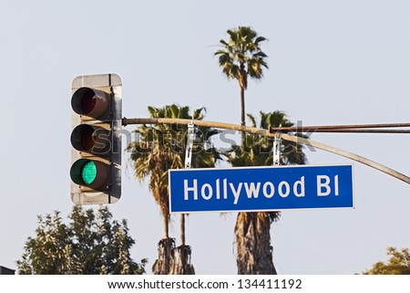 Hollywood Boulevard Sign with Palm Trees and Traffic Signal Light