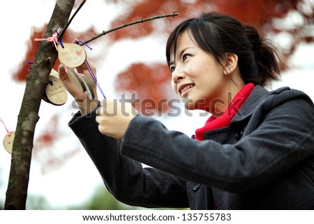 asian woman blessing with autumn tree background taken in Korea