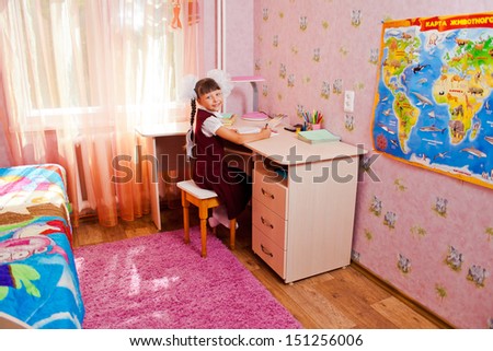 School girl doing homework in her room