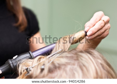 Hairdresser to curl the hair in a beauty salon
