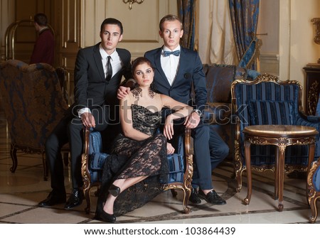 Two men and woman posing in luxury interior