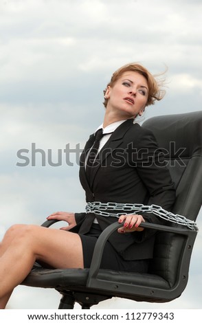 Out of office - working woman chained to her armchair