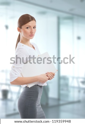Beautiful young office lady holding a white folder in her hands
