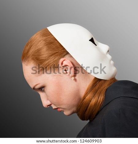 Two faces. Red head woman with white mask worn on the back of her head