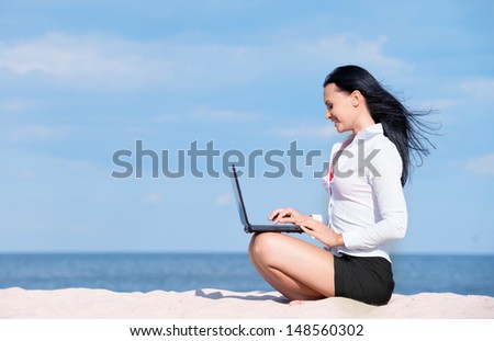 Portrait of office lady with laptop at the beach