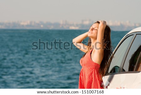 Portrait of a pretty girl in front of the sea with city landscape