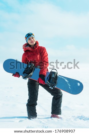 Woman holding snowboard and looking up