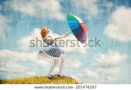 Retro style portrait of a girl with colorful umbrella in the wind