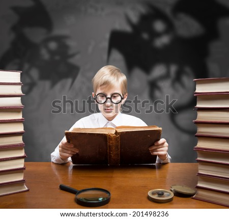Retro style portrait of a boy reading the old book of spooky stories