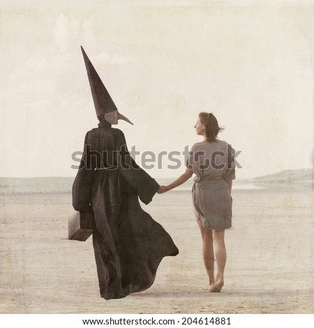 Woman walking away through the desert accompanied by the mysterious person in the plague mask, view from back