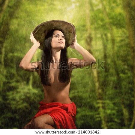 Portrait of a pretty woman with bamboo hat, rainy jungle background