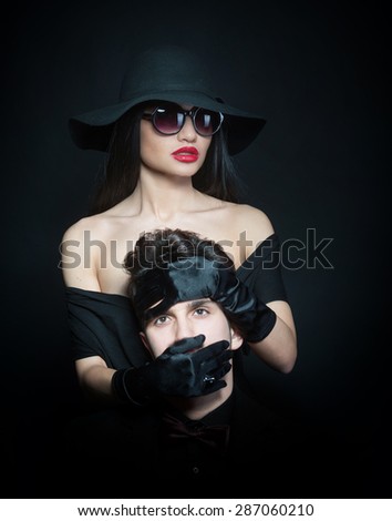 Woman covering the mouth of a man with her hands