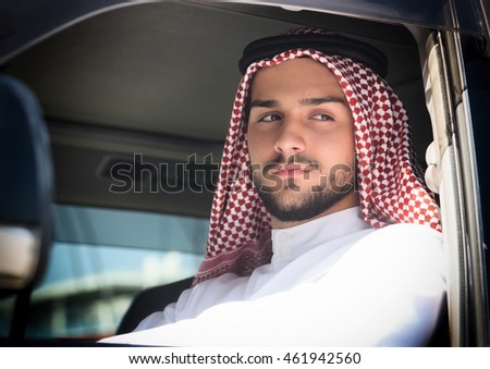 Portrait of a handsome arabian man driving a car